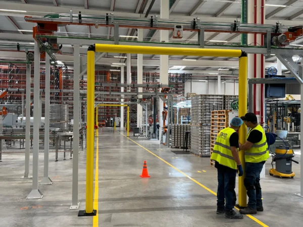 Montadores ajustando el poste de un pórtico sobre el pasillo peatonal