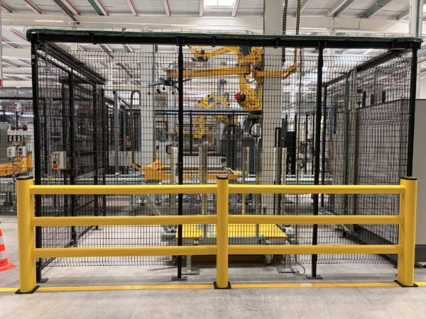 Barandilla de tres travesaños delante del vallado de una célula robotizada